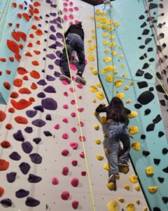 For youth with low vision, the routes with bright pink and yellow holds offer better contrast and visibility. One of the girls had long decorated acrylic nails and surprised us by climbing very well. This is truly adaptive indoor rock climbing.